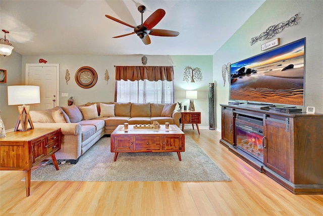 living room with ceiling fan, light hardwood / wood-style floors, and lofted ceiling