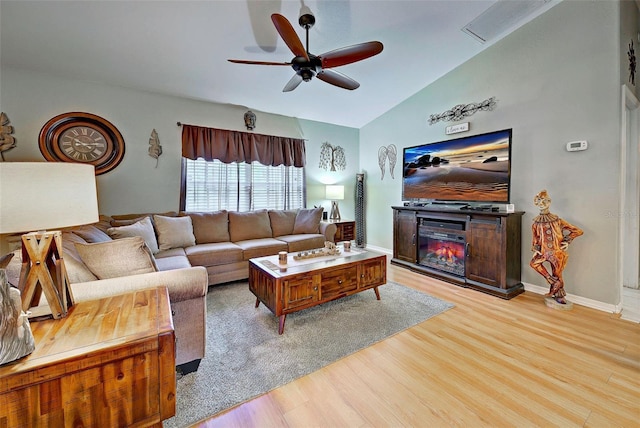 living room featuring ceiling fan, vaulted ceiling, and light wood-type flooring