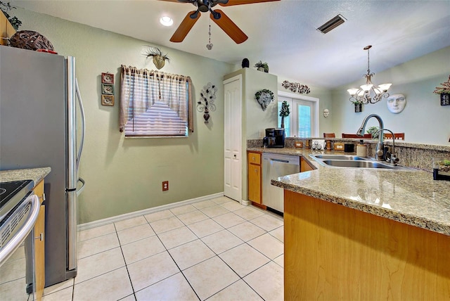 kitchen featuring pendant lighting, ceiling fan with notable chandelier, sink, light stone countertops, and appliances with stainless steel finishes