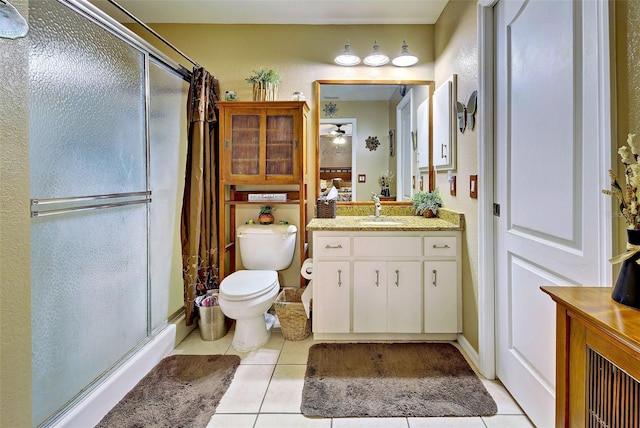 bathroom featuring tile patterned floors, vanity, toilet, and a shower with shower door