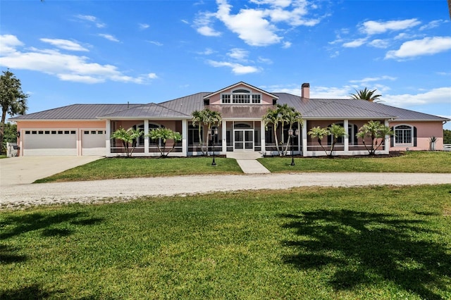 single story home featuring a garage, a front lawn, and a porch