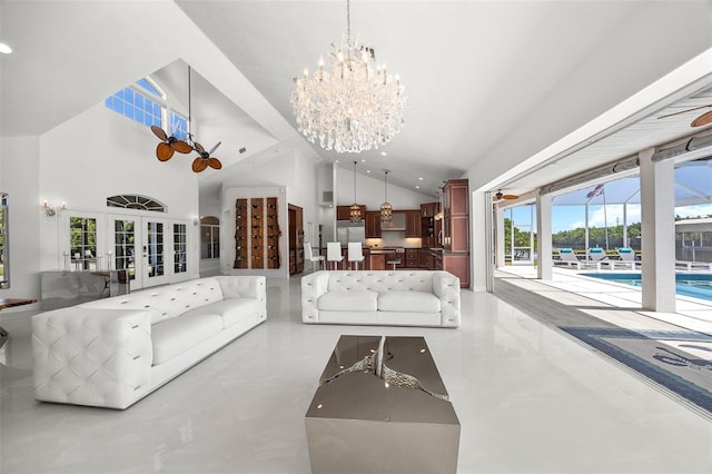 tiled living room featuring a notable chandelier, high vaulted ceiling, and french doors