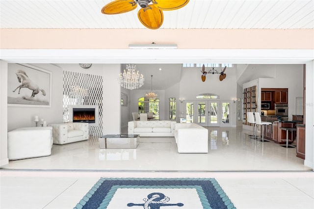 living room with tile floors and ceiling fan with notable chandelier