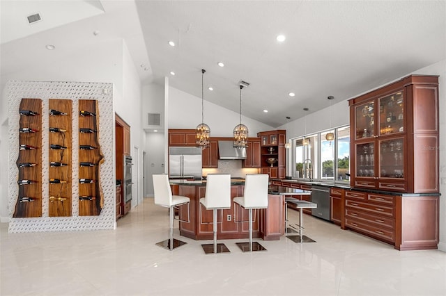 kitchen featuring stainless steel appliances, pendant lighting, a kitchen island, light tile floors, and a breakfast bar area