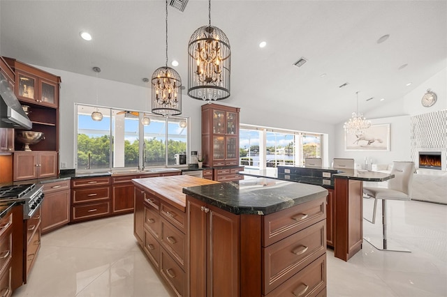 kitchen with a center island, a notable chandelier, a breakfast bar area, and light tile floors