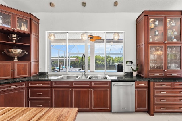 kitchen featuring stainless steel dishwasher, dark stone counters, pendant lighting, sink, and light tile floors