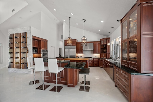 kitchen with a kitchen island, a kitchen breakfast bar, light tile floors, and built in appliances