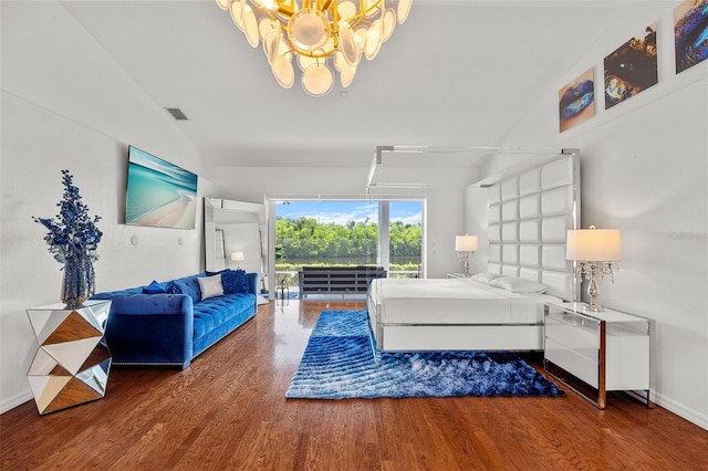 living room with an inviting chandelier, hardwood / wood-style floors, and vaulted ceiling