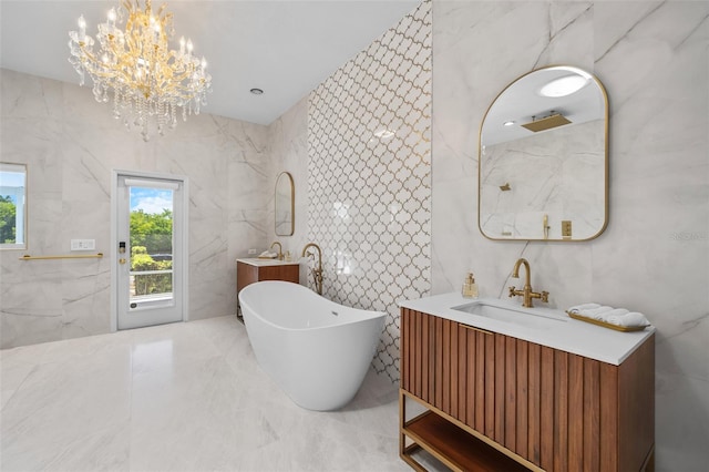 bathroom featuring a bathtub, vanity, a chandelier, and tile walls