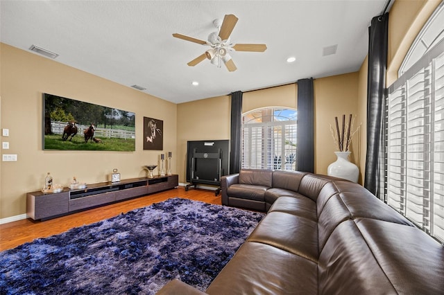 living room with wood-type flooring and ceiling fan