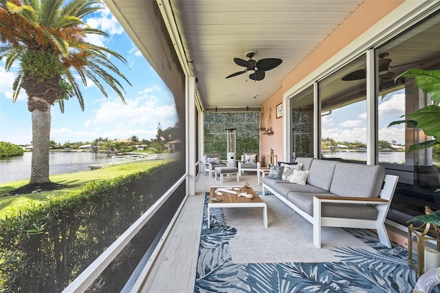 sunroom / solarium with a water view and ceiling fan