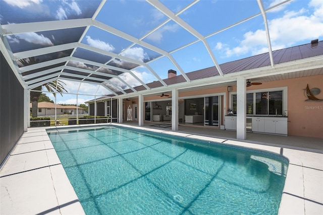 view of swimming pool featuring ceiling fan, a lanai, and a patio