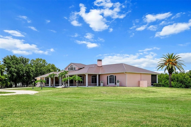 rear view of property featuring a lawn