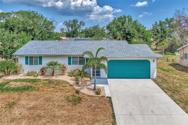 single story home featuring a garage and a front lawn