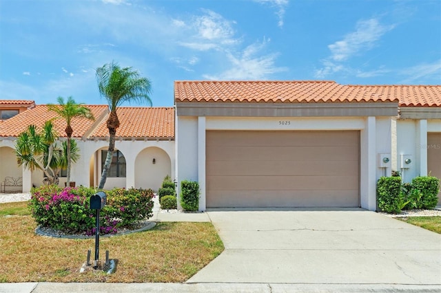 mediterranean / spanish-style home with a front yard and a garage