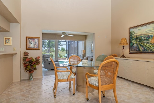 dining room with a high ceiling, ceiling fan, and light tile patterned flooring