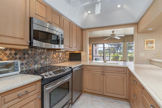 kitchen featuring sink, stainless steel appliances, tasteful backsplash, kitchen peninsula, and light tile patterned flooring