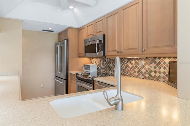 kitchen featuring decorative backsplash, ceiling fan, stainless steel appliances, and light stone counters