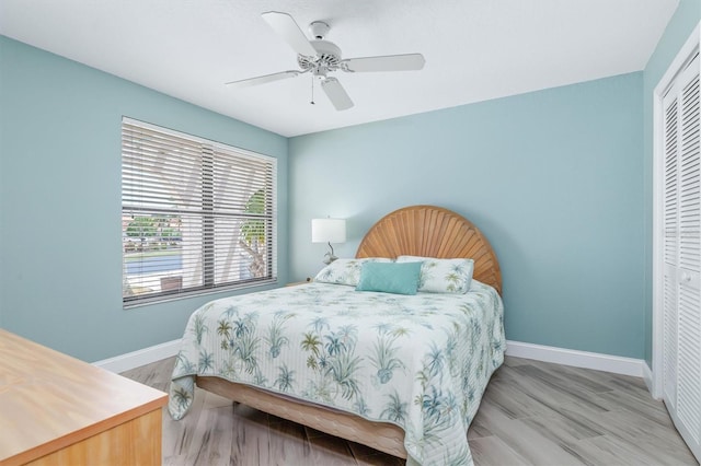 bedroom with ceiling fan, a closet, and light wood-type flooring