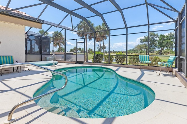 view of pool featuring glass enclosure and a patio area