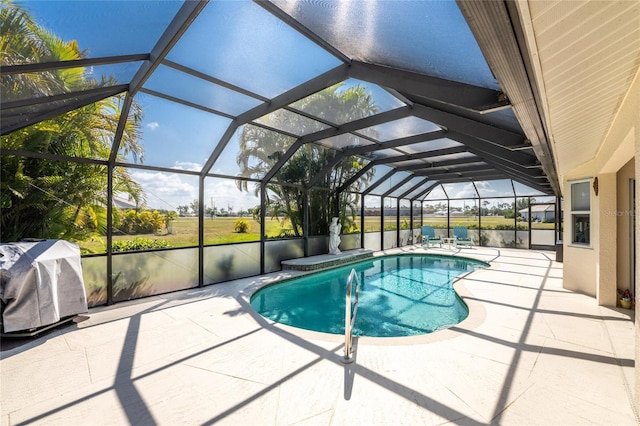 view of swimming pool with area for grilling, glass enclosure, and a patio area