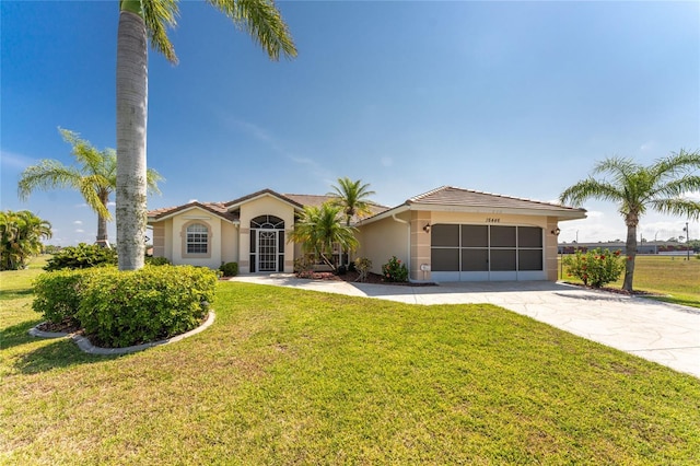 mediterranean / spanish-style house featuring a garage and a front lawn