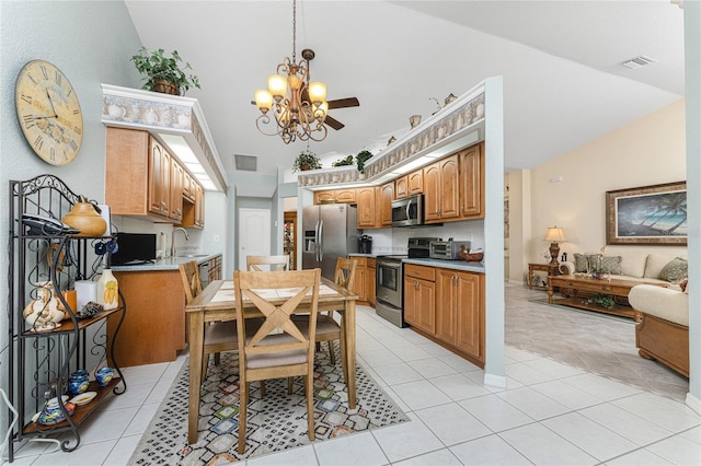 kitchen with light tile patterned flooring, sink, an inviting chandelier, vaulted ceiling, and appliances with stainless steel finishes