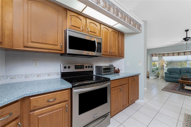 kitchen with backsplash, light tile patterned floors, ceiling fan, and appliances with stainless steel finishes