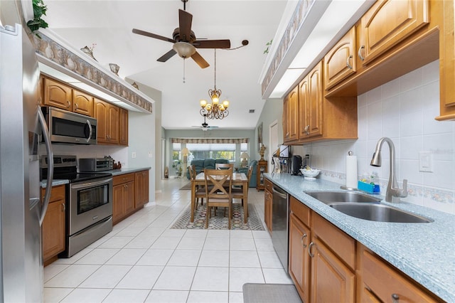 kitchen with sink, light tile patterned floors, stainless steel appliances, ceiling fan with notable chandelier, and decorative backsplash