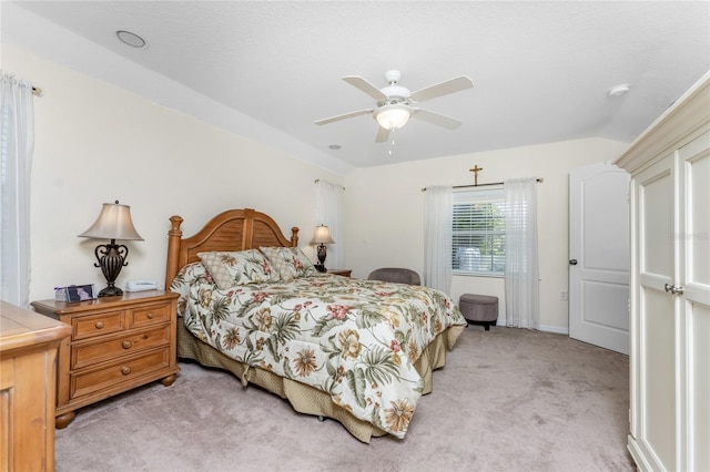 bedroom featuring ceiling fan, vaulted ceiling, and light carpet