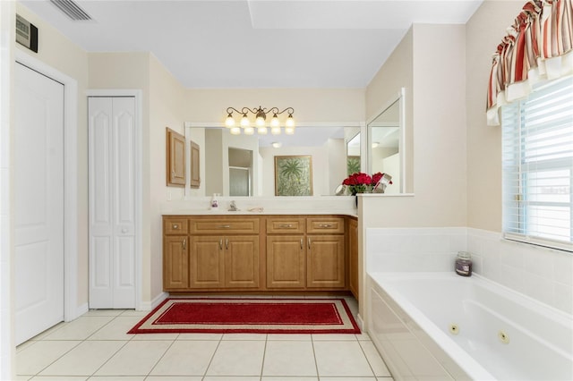 bathroom featuring vanity, a relaxing tiled tub, and tile patterned floors