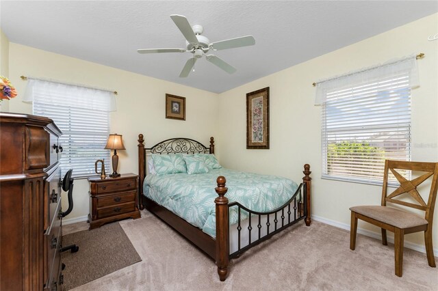 bedroom with ceiling fan and light colored carpet