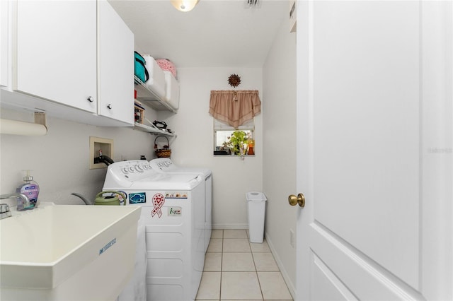 washroom with cabinets, light tile patterned flooring, sink, and independent washer and dryer