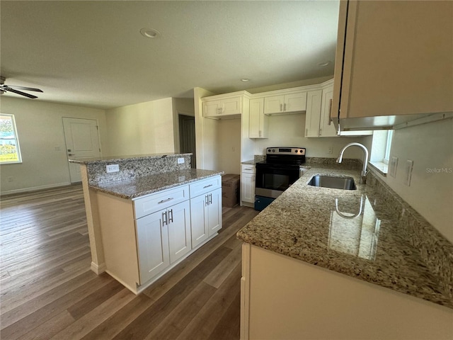 kitchen with sink, white cabinets, stainless steel range with electric stovetop, and dark wood-type flooring