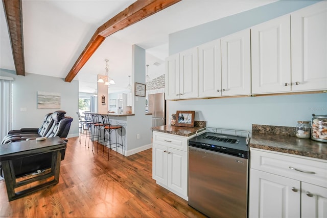 kitchen with stainless steel appliances, dark wood-type flooring, lofted ceiling with beams, dark stone countertops, and white cabinets