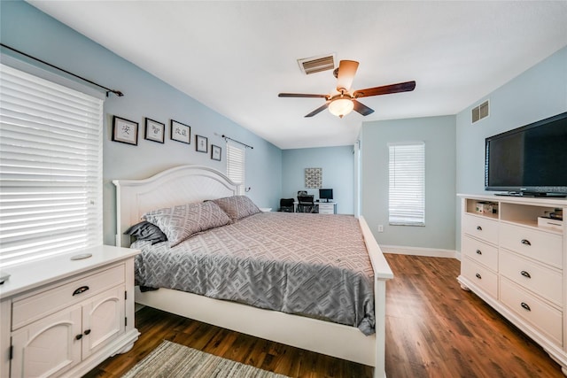 bedroom with ceiling fan, dark hardwood / wood-style flooring, and multiple windows