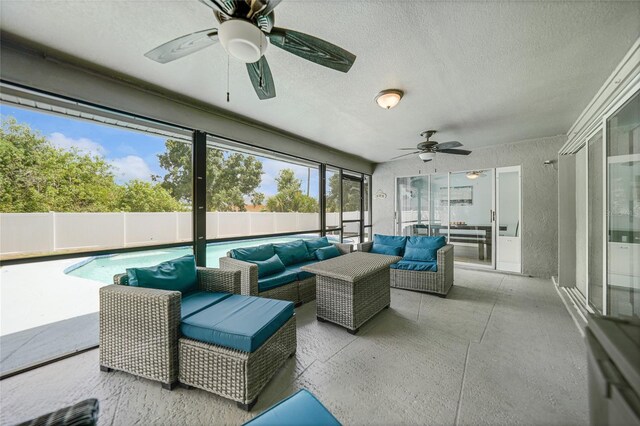 sunroom with ceiling fan and a pool