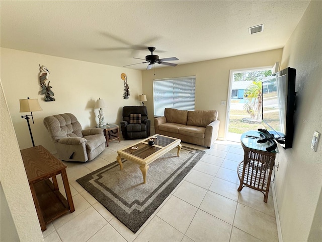 living area with visible vents, ceiling fan, a textured ceiling, and light tile patterned flooring