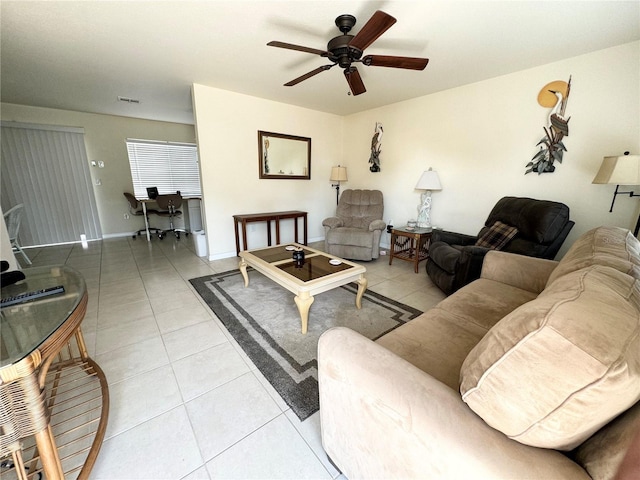 living area with light tile patterned floors, ceiling fan, visible vents, and baseboards