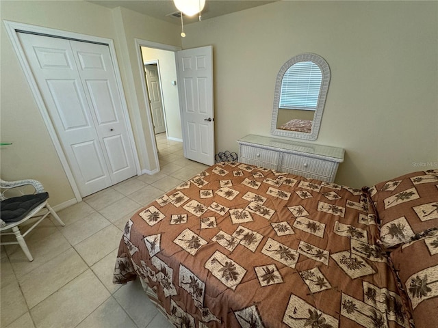 bedroom with light tile patterned floors, baseboards, and a closet