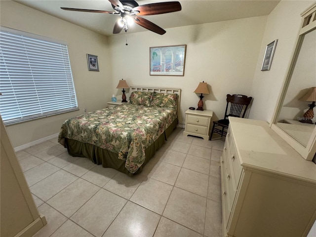 bedroom featuring light tile patterned floors, baseboards, and a ceiling fan