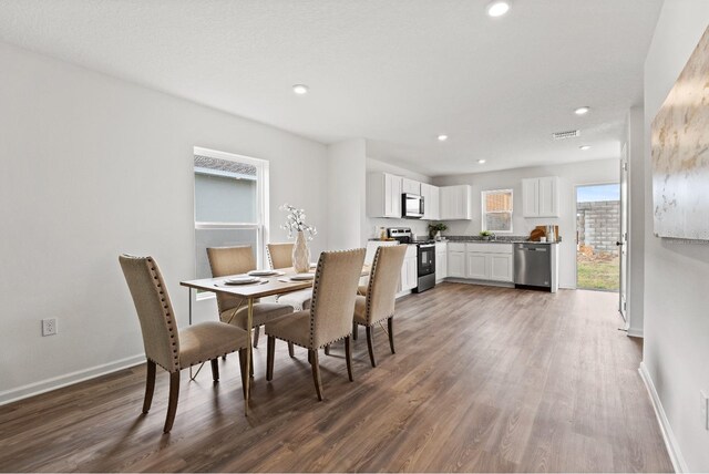 dining area featuring sink and dark wood-type flooring