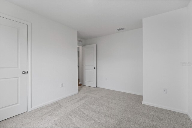 spare room featuring light colored carpet