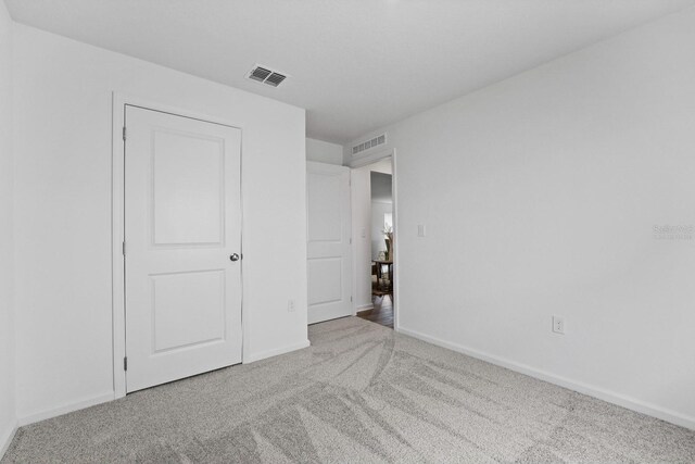 unfurnished bedroom with light colored carpet