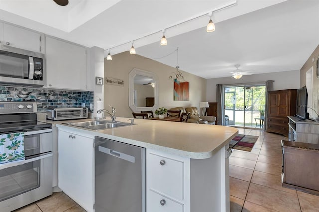 kitchen with white cabinets, ceiling fan, decorative backsplash, kitchen peninsula, and stainless steel appliances