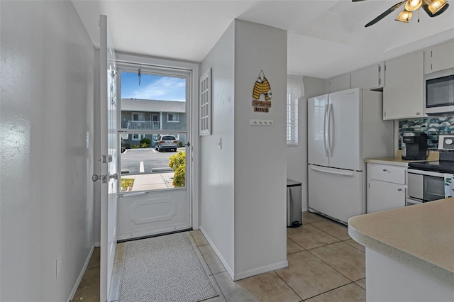 kitchen with range with electric cooktop, white cabinets, a healthy amount of sunlight, and white refrigerator