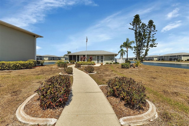 single story home with a water view and a front lawn