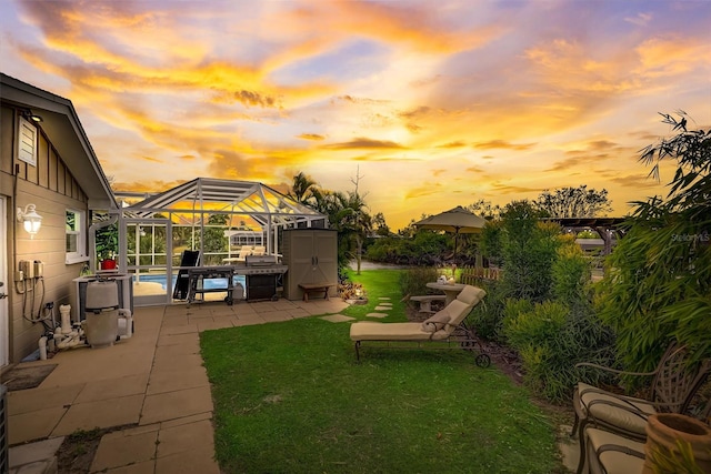 yard at dusk with a lanai and a patio area