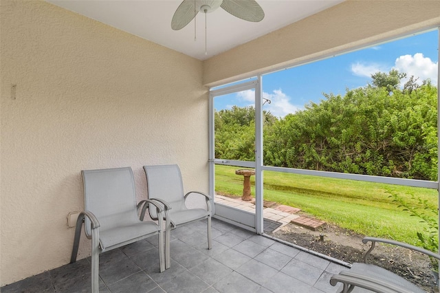 unfurnished sunroom with ceiling fan