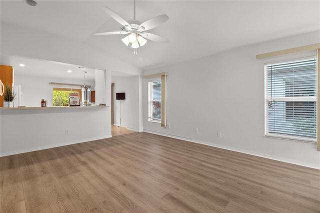 unfurnished living room with hardwood / wood-style flooring, vaulted ceiling, and ceiling fan